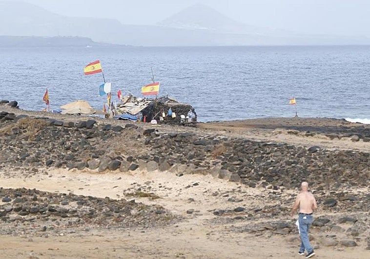 Un vecino camina cerca de uno de los búnkeres que está ocupado en El Confital.