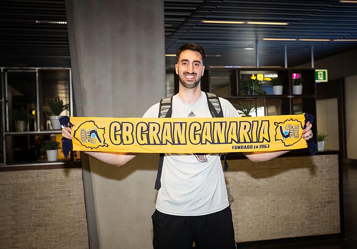 El jugador catalán Eric Vila posó ayer sonriente con la bufanda del Club Baloncesto Gran Canaria a su llegada a la isla.