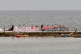 Imágenes de los vecinos de las Torres desplegando carteles en la Playa de las Canteras y en la barra