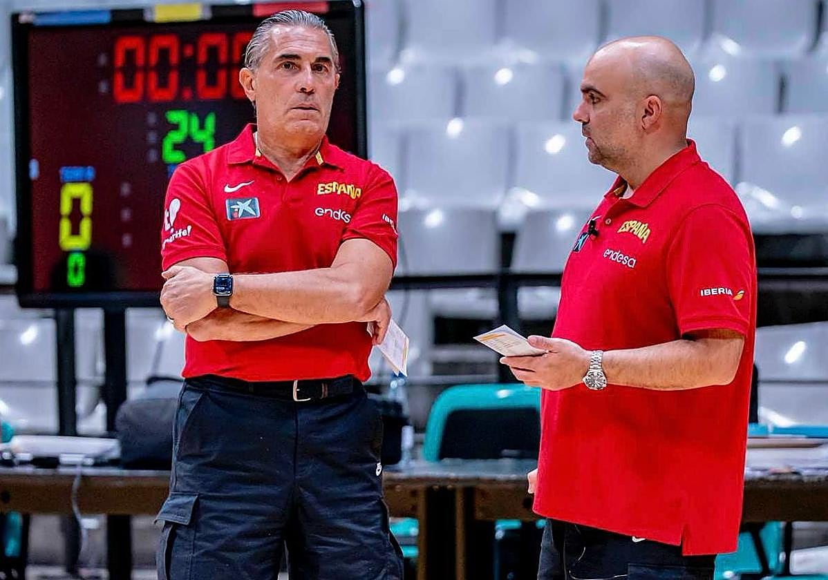 Víctor García -derecha- conversa con el seleccionador Sergio Scariolo en un entrenamiento de España.