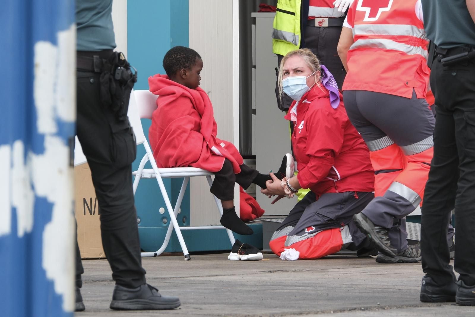 Imagen de archivo de un menor siendo atendido por una trabajadora de Cruz Roja en su llegada a las costas canarias.
