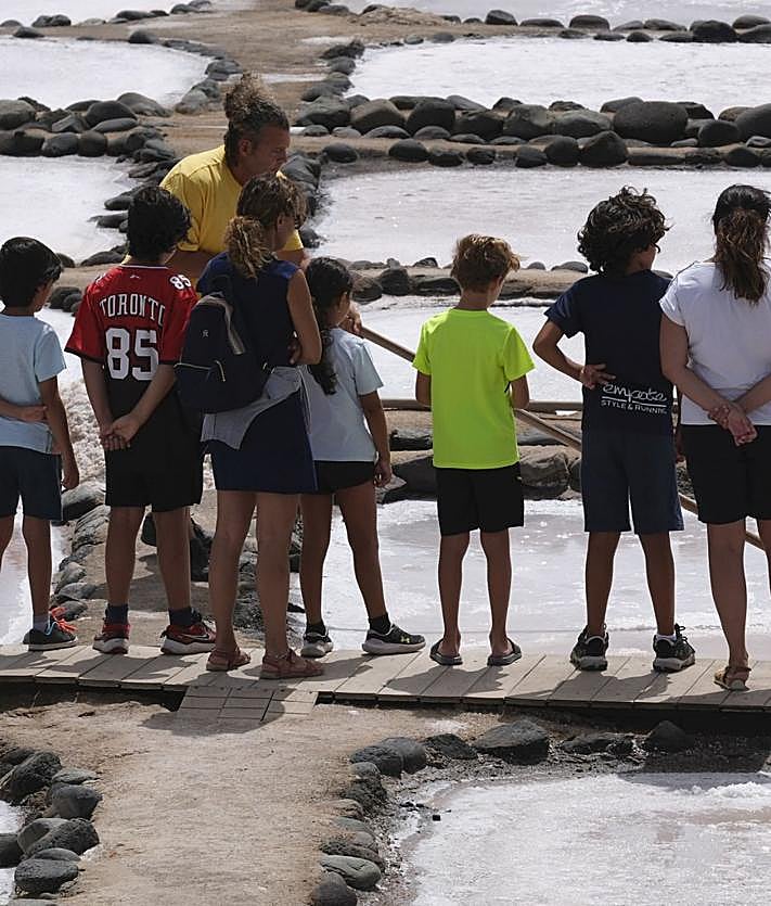 Imagen secundaria 2 - 1. Una montaña de sal en uno de los tajos de las salinas. 2. Windsurfistas surcando las olas de Pozo Izquierdo. 3. Un grupo de visitantes presta atención a las explicaciones de Navarro.