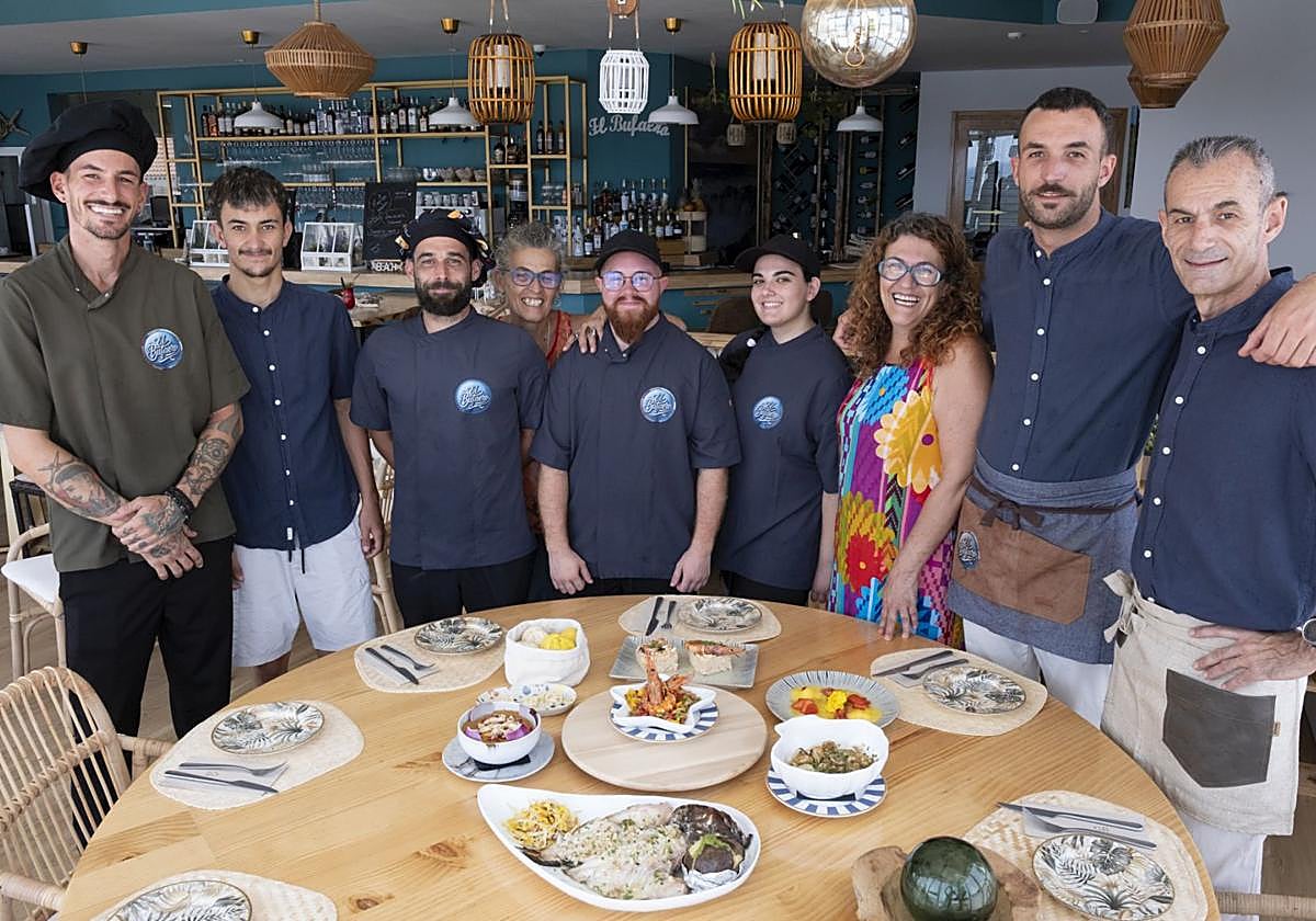 La familia Medina y empleados alrededor de una mesa con algunos de sus mejores platos.