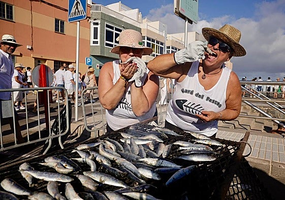 Dos personas cocinando sardinas en La Vará.
