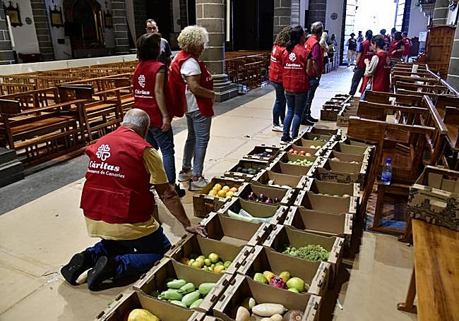 Voluntarios de Cáritas ordenando las ofrendas en el interior de la basílica.