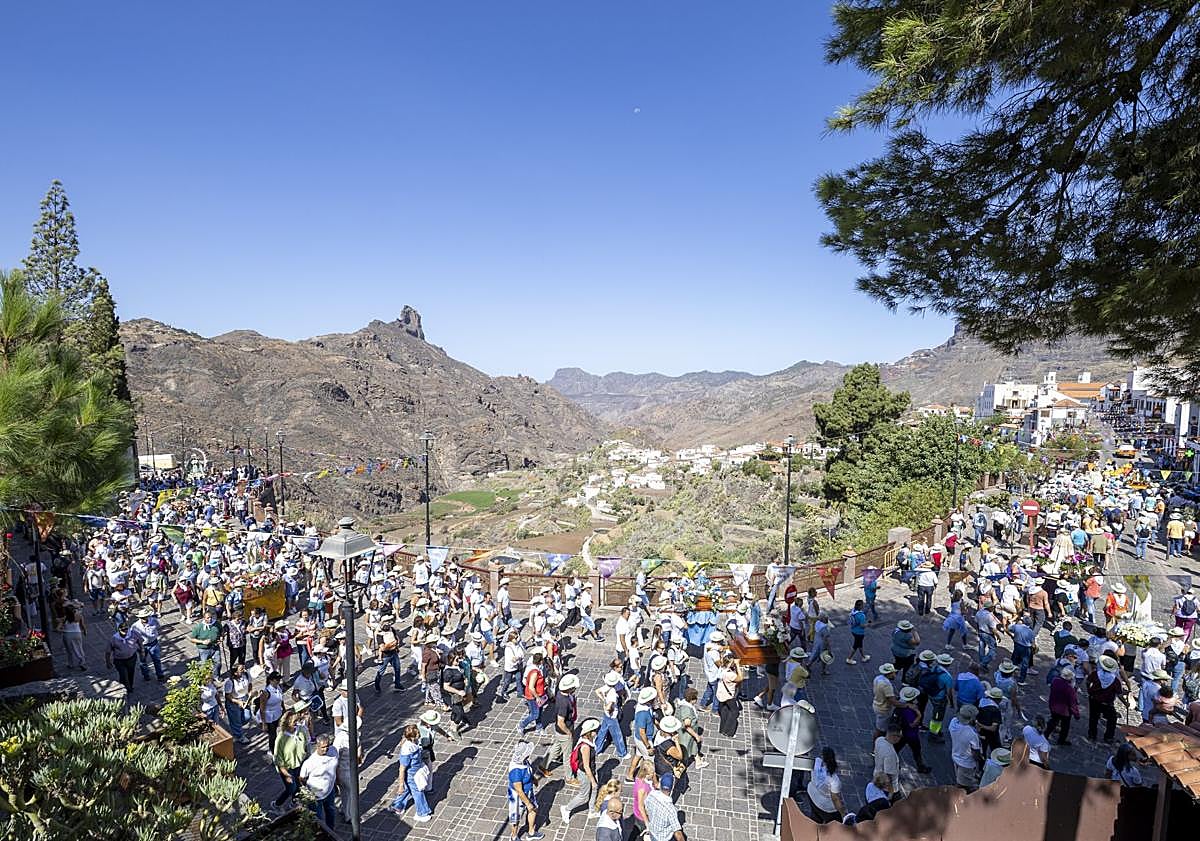 Imagen principal - Procesión por la calle principal del casco hacia la iglesia, cargos públicos junto a la Virgen del Socorro (con el alcalde, en el centro, y a su derecha, el vicepresidente segundo y consejero de Presidencia del Cabildo, Teodoro Sosa), y joven portando el trono de una de las imágenes.