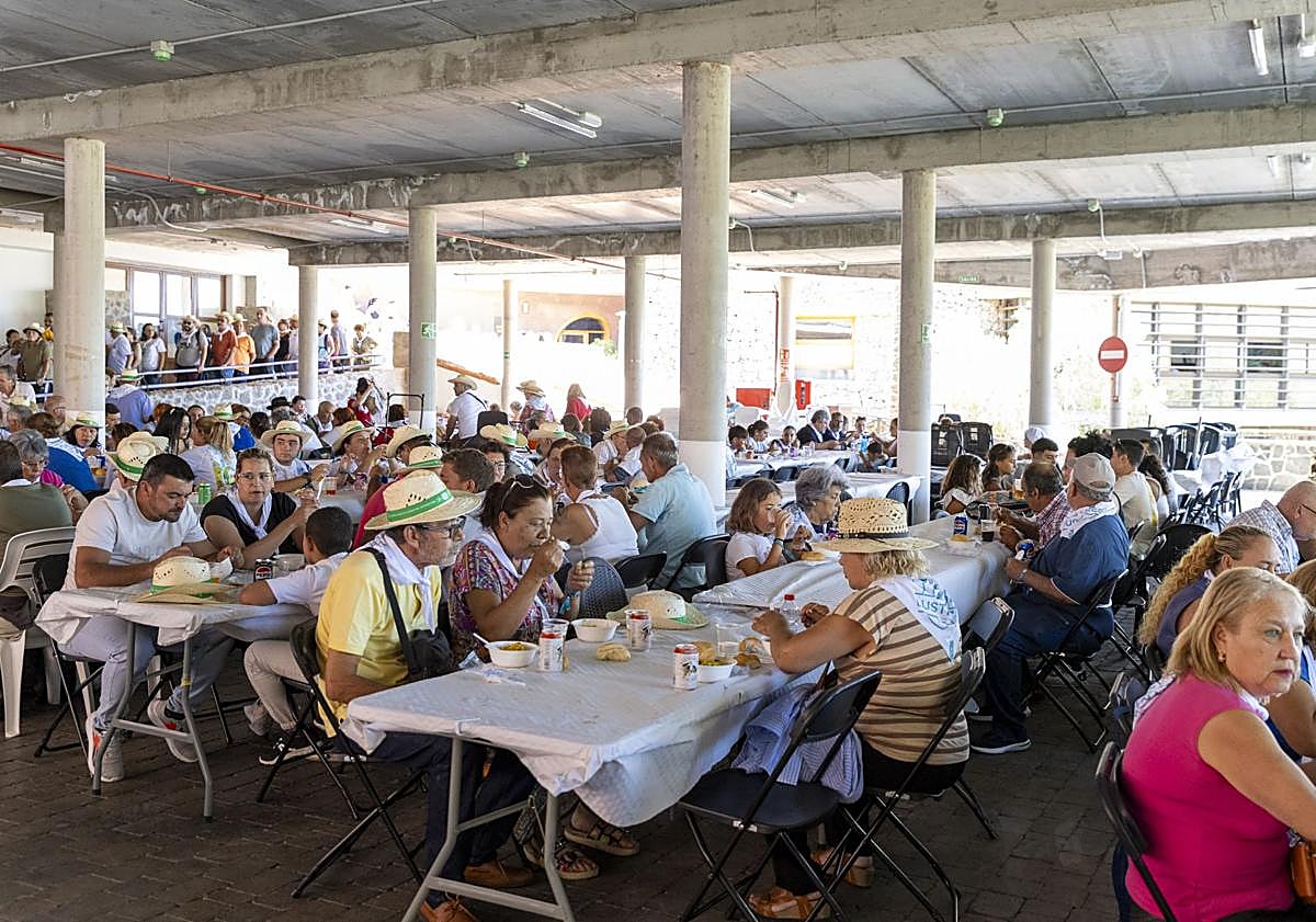 Imagen principal - Almuerzo popular tras la misa. grupo folclórico dentro del templo y peregrinación de varias imágenes con el Roque Bentayga de fondo.