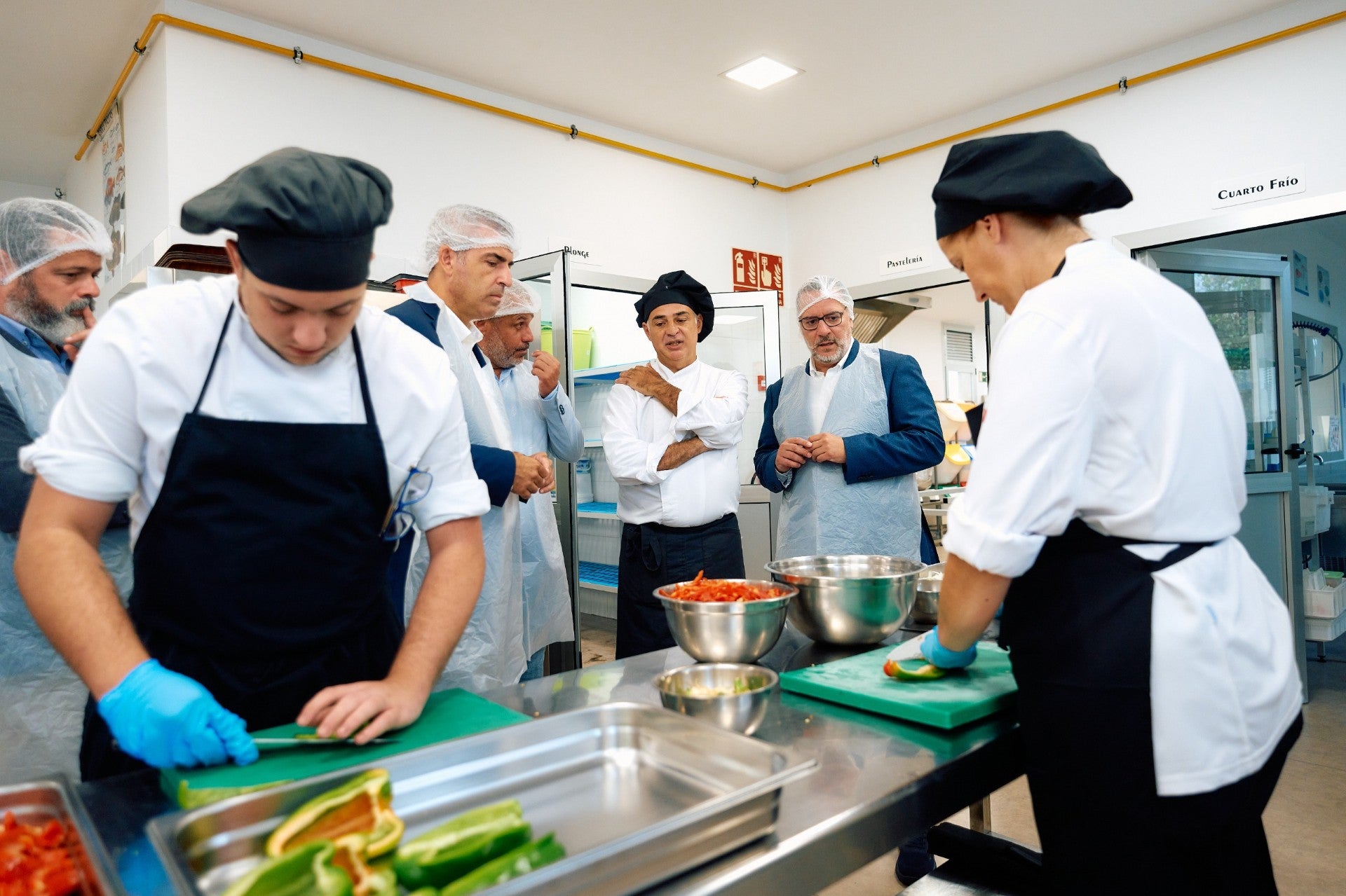 Manuel Domónguez, Poli Suárez y el alcalde de Guía junto a estudiantes de Cocina del CIFP Santa María de Guía este lunes.