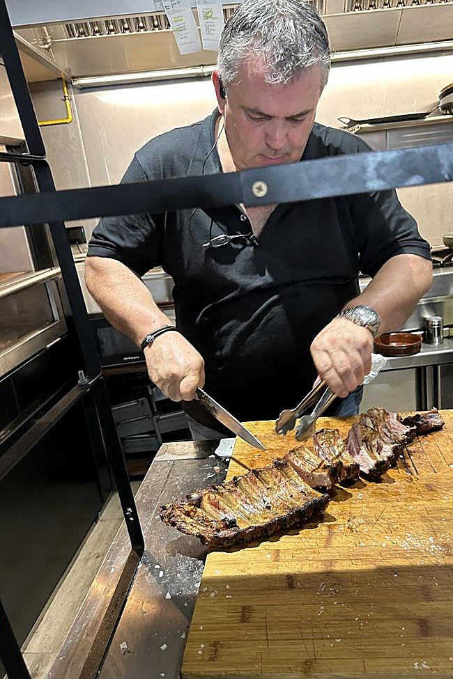 El parrillero de Casa Carmen en Betanzos trinchando churrascos