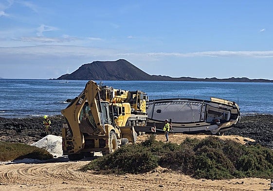Los trabajos de retirada de la embarcación empezaron este jueves por la mañana en la playa del Medio, en Corralejo.