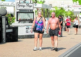 Turistas paseando por un paseo costero de Puerto del Carmen.