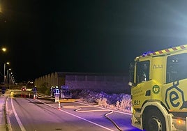 Bomberos extinguiendo el fuego del vehículo.
