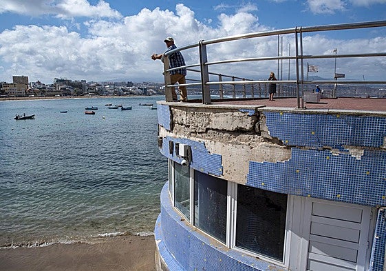 Un hombre se asoma a la playa de Las Canteras sobre el balneario de La Puntilla, que presenta un avanzado estado de deterioro.