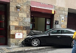 Imagen del coche estampado contra la fachada de la peluquería.