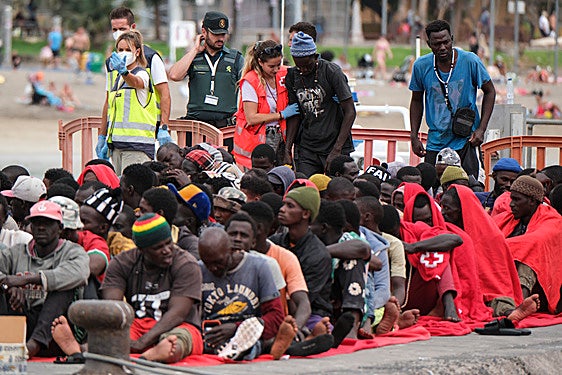 Imagen de los ocupantes del cayuco siendo atendidos por miembros de la Cruz Roja.