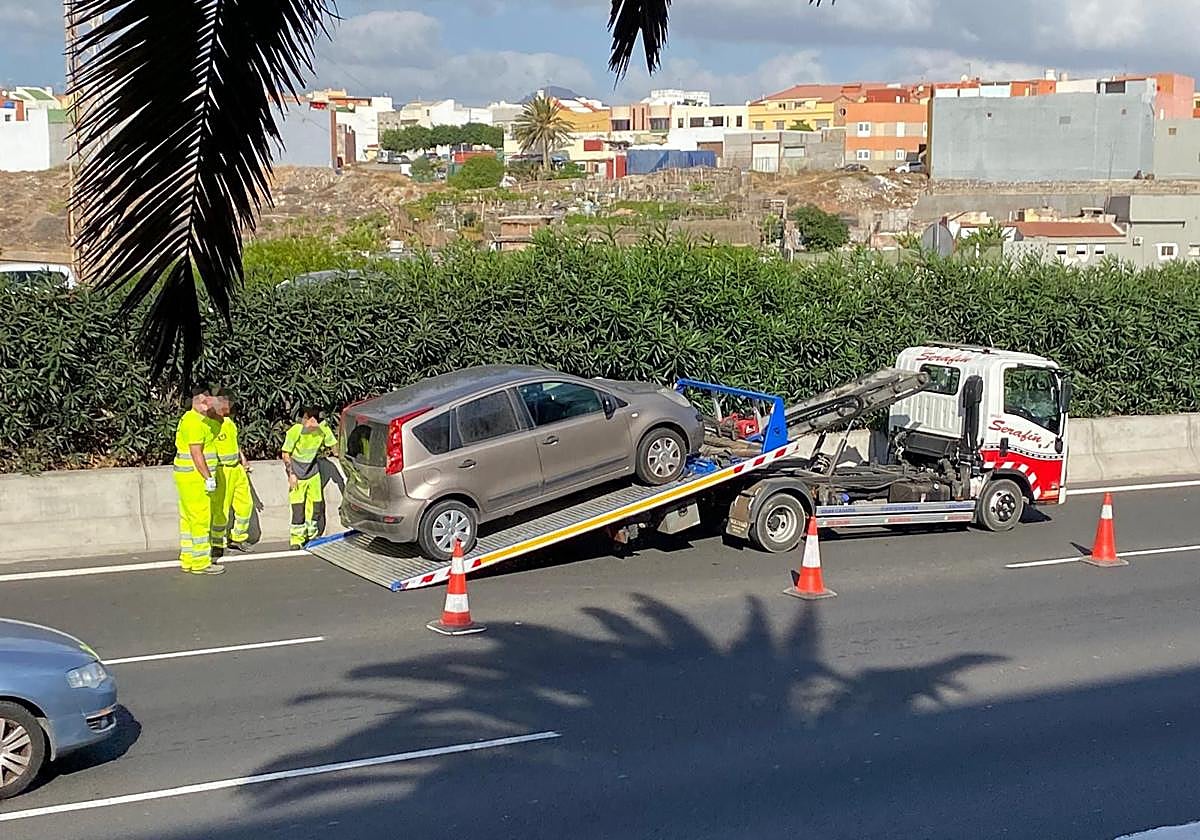 La grúa de una aseguradora procede a la retirada de un vehículo accidentado en la GC-1.
