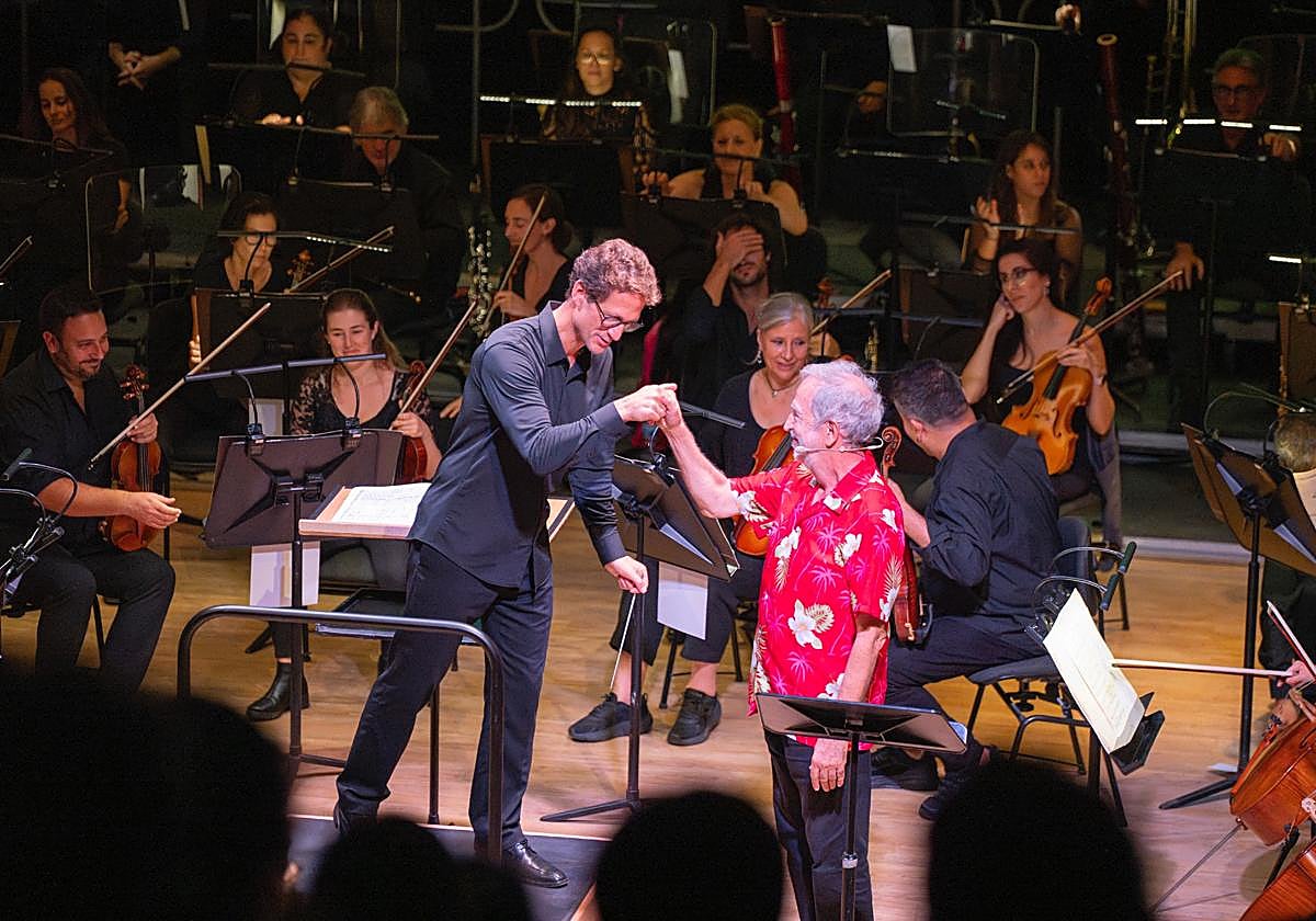 Fernando Palacios, de rojo, junto a la OFGC en el concierto educativo 'Peer Gynt'.