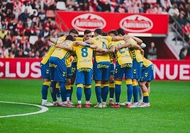 Piña de los jugadores de la UD en el césped del estadio del Sporting poco antes del inicio del encuentro del pasado domingo.