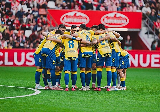 Piña de los jugadores de la UD en el césped del estadio del Sporting poco antes del inicio del encuentro del pasado domingo.