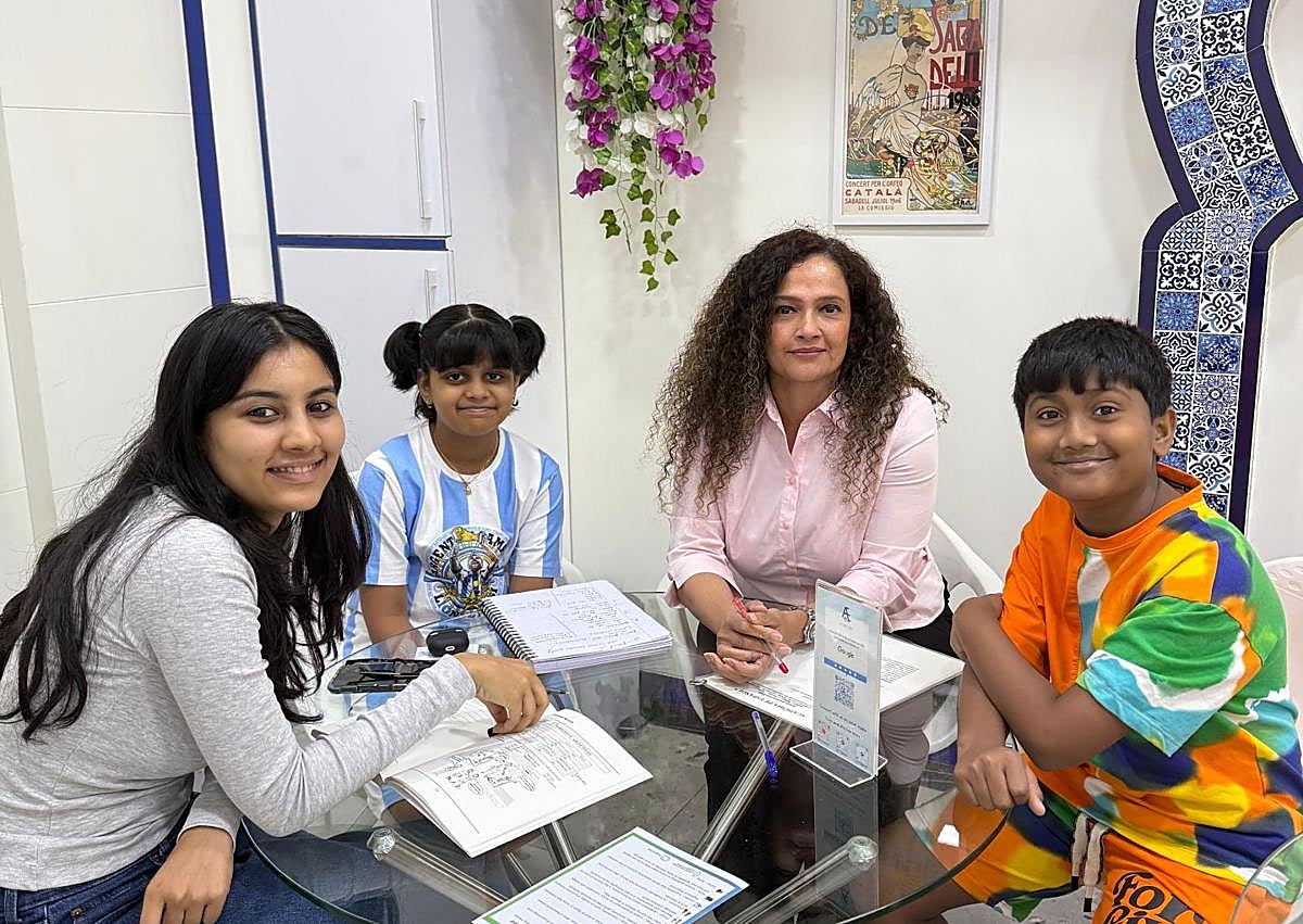 Imagen secundaria 1 - Dinesh Govindani (sentado) con un grupo de alumnos y distintos momentos de las clases. 