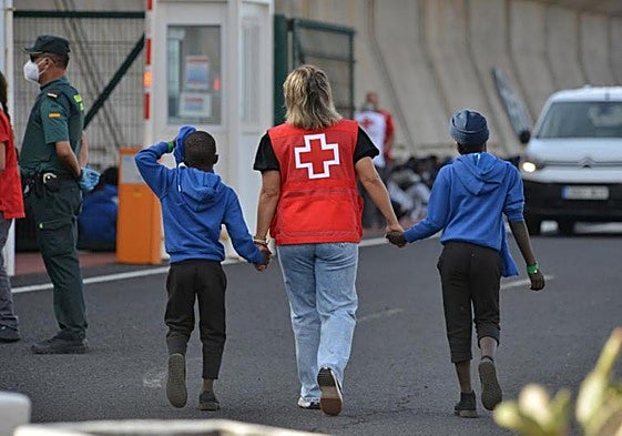 Una voluntaria junto a dos menores migrantes no acompañados llegados a Canarias.
