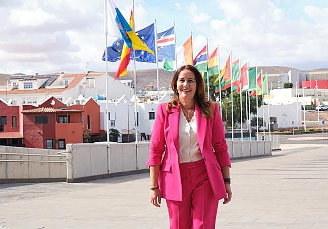 Lola García, en el exterior del Palacio de Congresos, en Puerto del Rosario, con las banderas de los países participantes en Africagua ondeando.