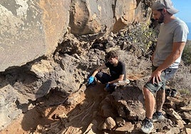 Dos arqueólogos frente a los restos óseos de uno de los individuos hallados en la exvacación.