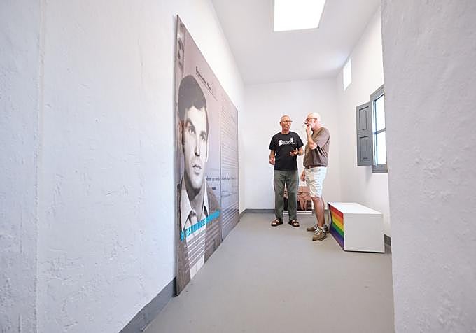 León Martín y Víctor Ramírez, al fondo. A la izquierda, panel con la foto, de joven, de Octavio García, uno de los homosexuales que estuvo preso en Tefía y que contó lo que allí vivió.