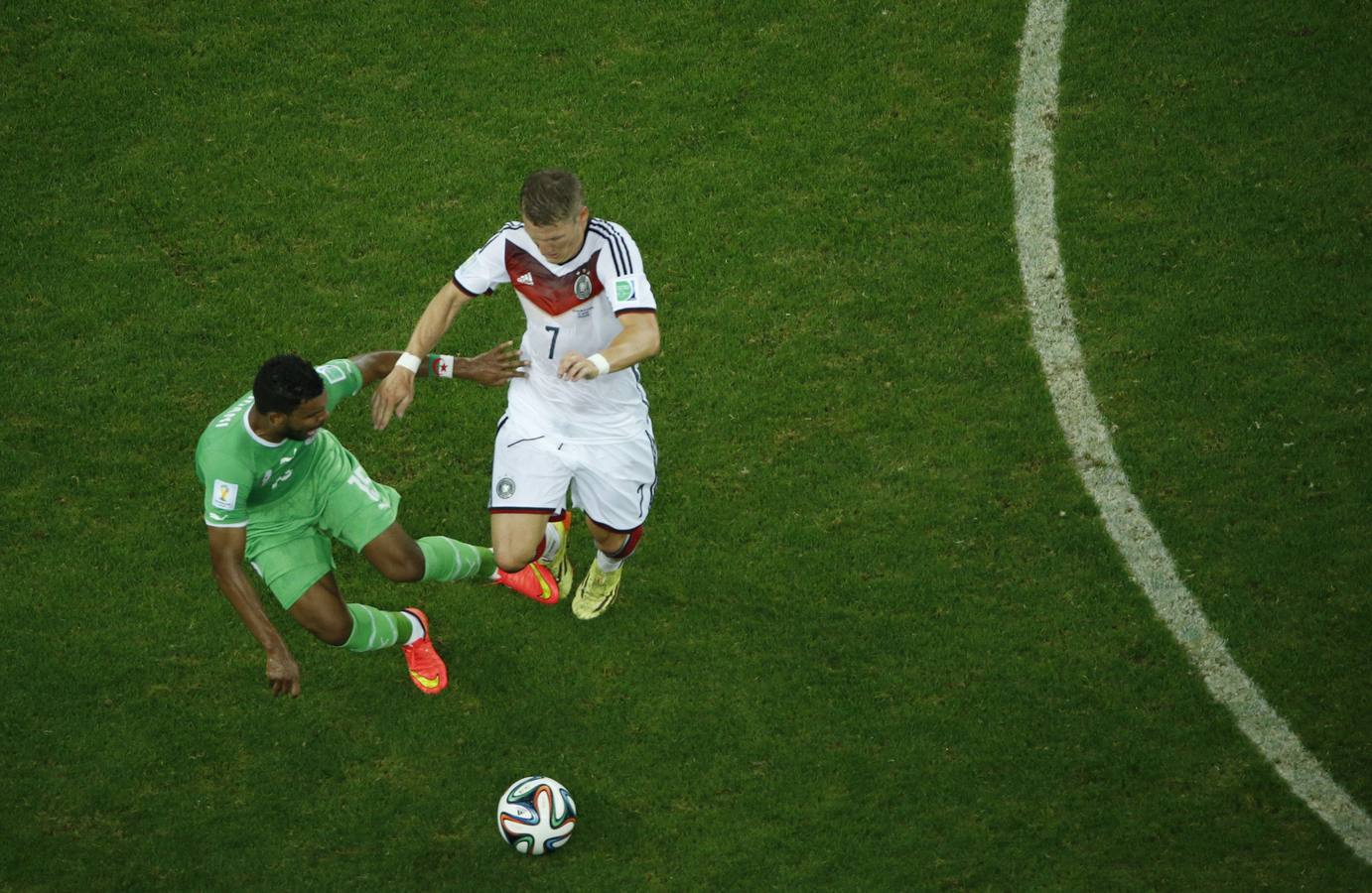 Schweinsteiger intenta llevarse la pelota ante un defensor argelino.