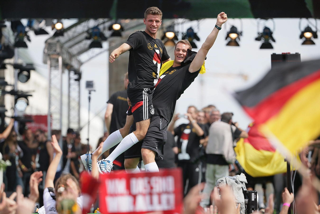 LA SELECCIÓN ALEMANA CELEBRA LA COPA DEL MUNDO CON MILES DE AFICIONADOS. Manuel Neuer y Thomas Mueller (i) celebran la Copa del Mundo de la FIFA con los aficionados durante la fiesta de bienvenida celebrada en honor del combinado alemán en la Puerta de Brandeburgo en Berlín.