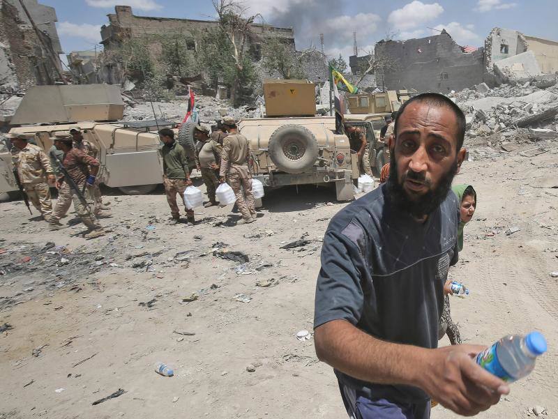 Ciudadanos iraquíes esperan para recibir comida