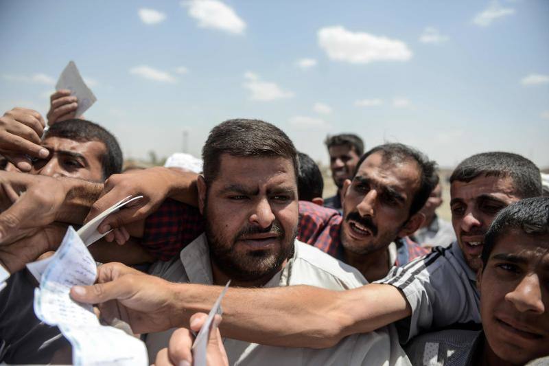 Ciudadanos iraquíes esperan para recibir comida
