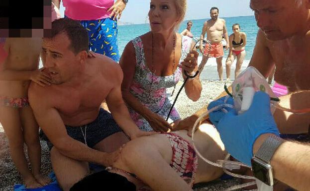 Varias personas atienden a la mujer una vez fuera del agua.