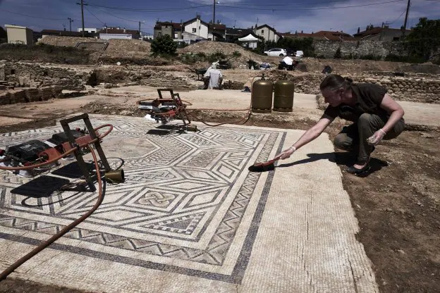 Un arqueólogo trabaja en uno e los mosaicos excavados en Viena, al sur de Francia, un «excepcional descubrimiento». :: J. P. Ksiazek / AFP