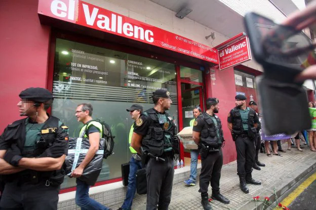 Efectivos de la Guardia Civil transportan cajas a su salida ayer del semanario 'El Vallenc'. :: j. sellart / efe