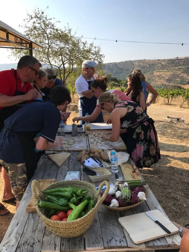 Un grupo de personas participa en un taller de cocina al aire libre organizado por Herrera.  sur