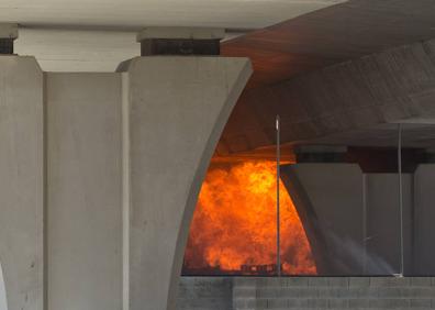 Imagen secundaria 1 - En la imagen superior, un operario retira los coches de un parking cercano. A la izquierda, las llamas afectaron a los pilares de la M-23. Al lado, agentes de Infoca sofocan otro incendio en una zona forestal de Puerto de la Torre.