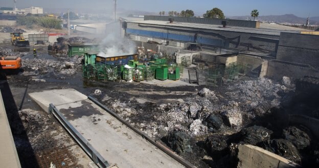 Los bomberos refrescaban ayer la zona mientras se iba retirando el material calcinado. :: ñito salas