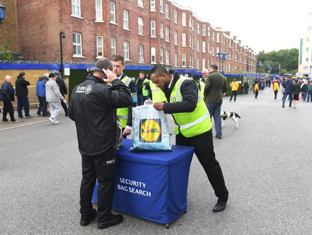 Personal de seguridad revisa las pertenencias de un joven, ayer antes del partido Chelsea-Arsenal. :: efe