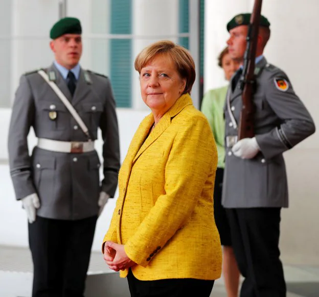 La canciller, Angela Merkel, fotografiada entre dos soldados en la Cancillería de Berlín. :: reuters
