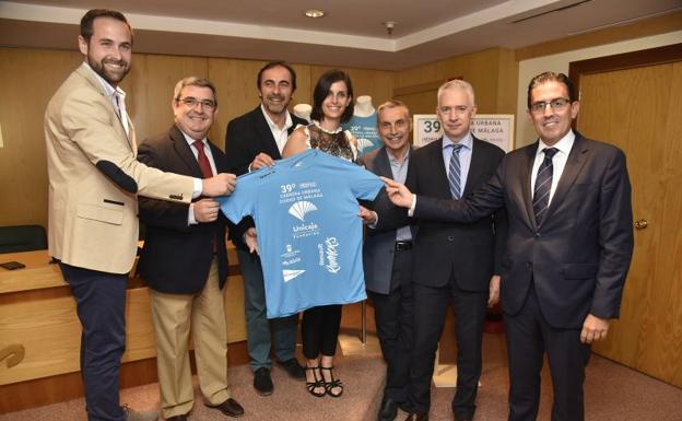 Los organizadores muestran la camiseta solidaria de esta edición que se puede adquirir por 3 euros.