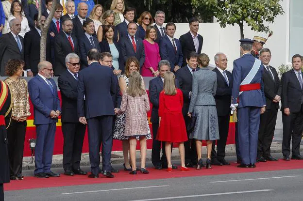 Los Reyes, la princesa de Asturias, la infanta Sofía y Rajoy saludan a las autoridades presentes en el desfile militar de ayer. 
