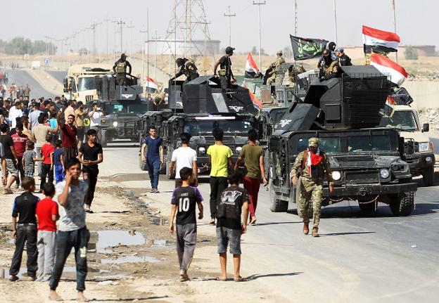 Ciudadanos salen a recibir a las fuerzas iraquíes a su llegada al primer barrio en el sur de la ciudad kurda de Kirkuk. :: ahmad al-rubaye / afp
