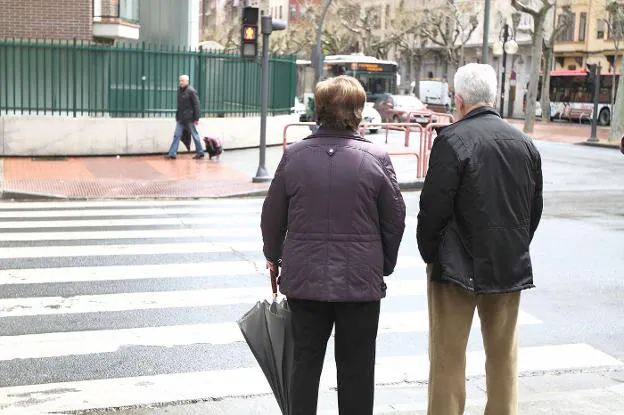 Una pareja de jubilados espera a cruzar una calle en Madrid.