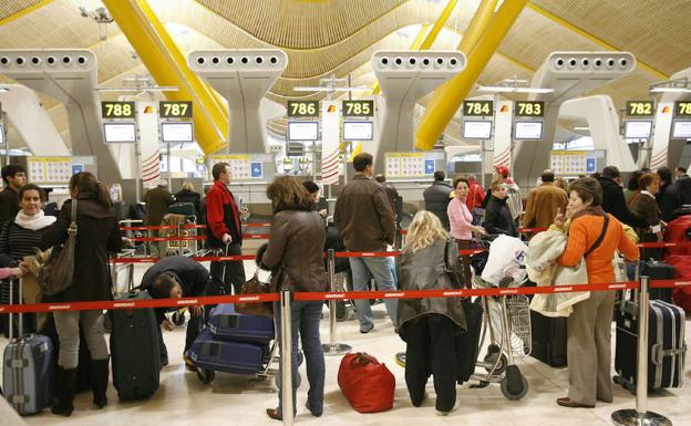 Numerosos viajeros esperan a facturar su maleta en el aeropuerto Madrid-Barajas.