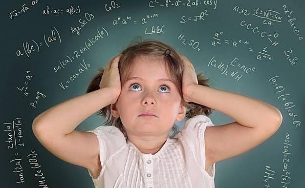 Una niña abrumada por las operaciones matemáticas se lleva las manos a la cabeza.