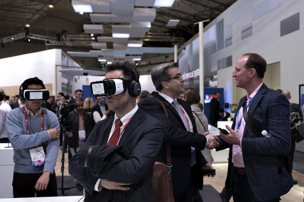 Varios asistentes al último congreso mundial de telefonía (MWC) prueban el uso de gafas de realidad virtual para su trabajo. 