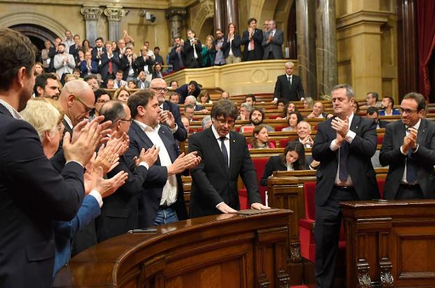 Diputados independentistas aplauden a Puigdemont tras su discurso del 10 de octubre en el Parlament. :: LLUIS GEné / afp