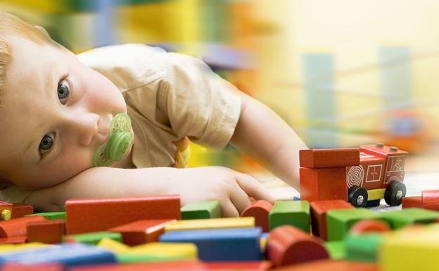 Un niño juega con bloques de madera. 