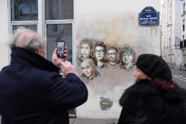 Retratos de las víctimas de 'Charlie Hebdo', junto a su sede. :: afp